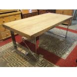 A contemporary farmhouse kitchen table, the rectangular stripped pine top raised on pair of polished