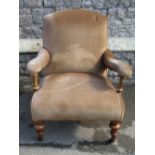 A Victorian open armchair with upholstered seat, scrolled back and arm rests, raised on turned and