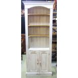 A pine floor standing side cupboard with painted and distressed finish, partially enclosed by a pair