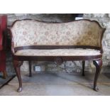 A small Edwardian two seat parlour sofa with shaped and moulded outline, upholstered pad seat and