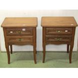 A pair of low oak two drawer bedside lamp tables with moulded detail raised on square tapered and