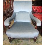 A Victorian armchair with light blue ground upholstered seat, scrolled back and arms and raised on