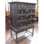 A Jacobean style oak chest on stand, the chest with three long and two short drawers, with applied