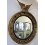 A Regency style gilt framed convex wall mirror, with ebonised reeded slip, ball surround and