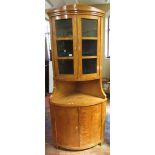 A Biedermeier free standing corner cupboard of full height, with bow fronted outline, the lower