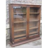 A Victorian walnut bookcase enclosed by a pair of rectangular glazed panelled doors with chamfered