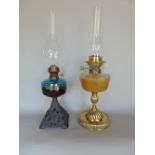 A good quality cast brass oil lamp with faceted glass reservoir upon a fluted baluster column,
