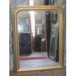 A Victorian style arched and gilded over mantel mirror, the moulded frame with beaded border,
