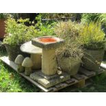 A weathered contemporary two sectional bird bath with rough hewn textured finish and square