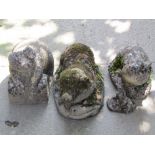 Four novelty weathered cast composition stone garden ornaments in the form of pigs in varying pose