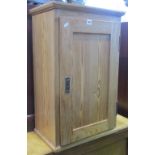 A continental stripped and waxed pine side/wall cupboard enclosed by a rectangular panelled door