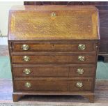 A Georgian oak walnut banded bureau of four long graduated drawers with embossed brass plate