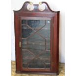 A 19th century mahogany hanging corner display cabinet with broken swan neck pediment over an