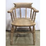 A pair of beechwood smokers bow elbow chairs, with turned spindle backs and raised on turned