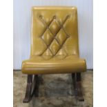 A reproduction Regency style low rocking chair with scrolled outline, buttoned upholstery and reeded