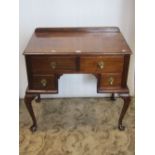 A small stained wooden kneehole dressing table fitted with an arrangement of four drawers raised