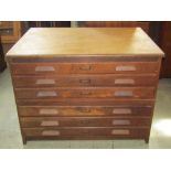 A vintage oak framed floorstanding two sectional plan chest of six long drawers with moulded handles