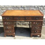 A reproduction Georgian style mahogany veneered kneehole twin pedestal writing desk with inset tan