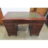 A reproduction Georgian style mahogany veneered kneehole twin pedestal writing desk with green inset