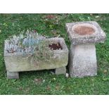 A weathered composition stone two sectional bird bath with rough hewn effect, together with a