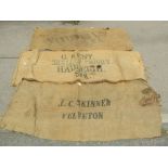A collection of vintage hessian sacks with various printed merchants advertising