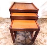 A nest of three graduated teak occasional tables of rectangular form, raised on square cut and