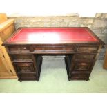 A good quality reproduction oak kneehole twin pedestal writing desk with inset red leather