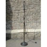 A contemporary cast metal adjustable standard lamp with partially reeded stem raised on a domed disc