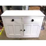 A Victorian pine kitchen dresser enclosed by two panelled doors and two drawers, with later