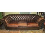 A substantial Victorian style three seat Chesterfield sofa, upholstered in a mid-brown leather, 2m