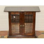 A small Edwardian/1920s oak wall or table cabinet, enclosed by a pair of bevelled edge rectangular