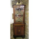 An inlaid Edwardian mahogany freestanding corner cabinet in the Georgian style enclosed by two