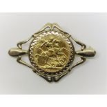 Sovereign dated 1911 mounted in a 9ct openwork brooch with bright cut decoration, 13.9g