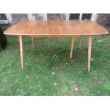 An Ercol blonde elm and beechwood pull out extending dining table of rectangular form with moulded