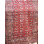 Bokhara runner with typical geometric medallion decoration upon a red ground, 480 x 130 cm