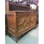 A medium to light oak dresser in the arts and crafts style, the recessed shallow raised back with