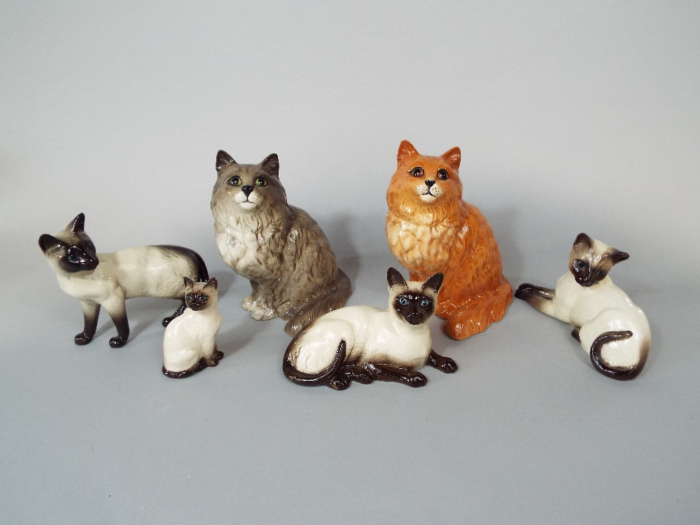 A collection of Beswick cats comprising a ginger seated example 1867, a grey example 1867, and