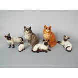 A collection of Beswick cats comprising a ginger seated example 1867, a grey example 1867, and