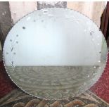 A vintage circular frameless wall mirror with crimped edge and foliate detail, 76cm diameter