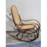 A vintage bentwood rocking chair, with scrolled frame and cane panel seat and back (unmarked but