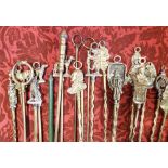 A large collection of various brass toasting forks, each with a novelty knop handle