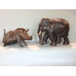 Two good quality carved studies of wildlife, one in the form of an elephant the other a warthog or