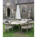 A Bramble Crest contemporary weathered teak garden table of oval form with slatted panelled top