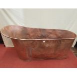 A copper slipper bath with single raised end and central plug hole, approx 150cm long x 70cm high