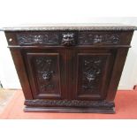 A Victorian carved oak side cupboard, the front elevation enclosed by a pair of panelled doors and