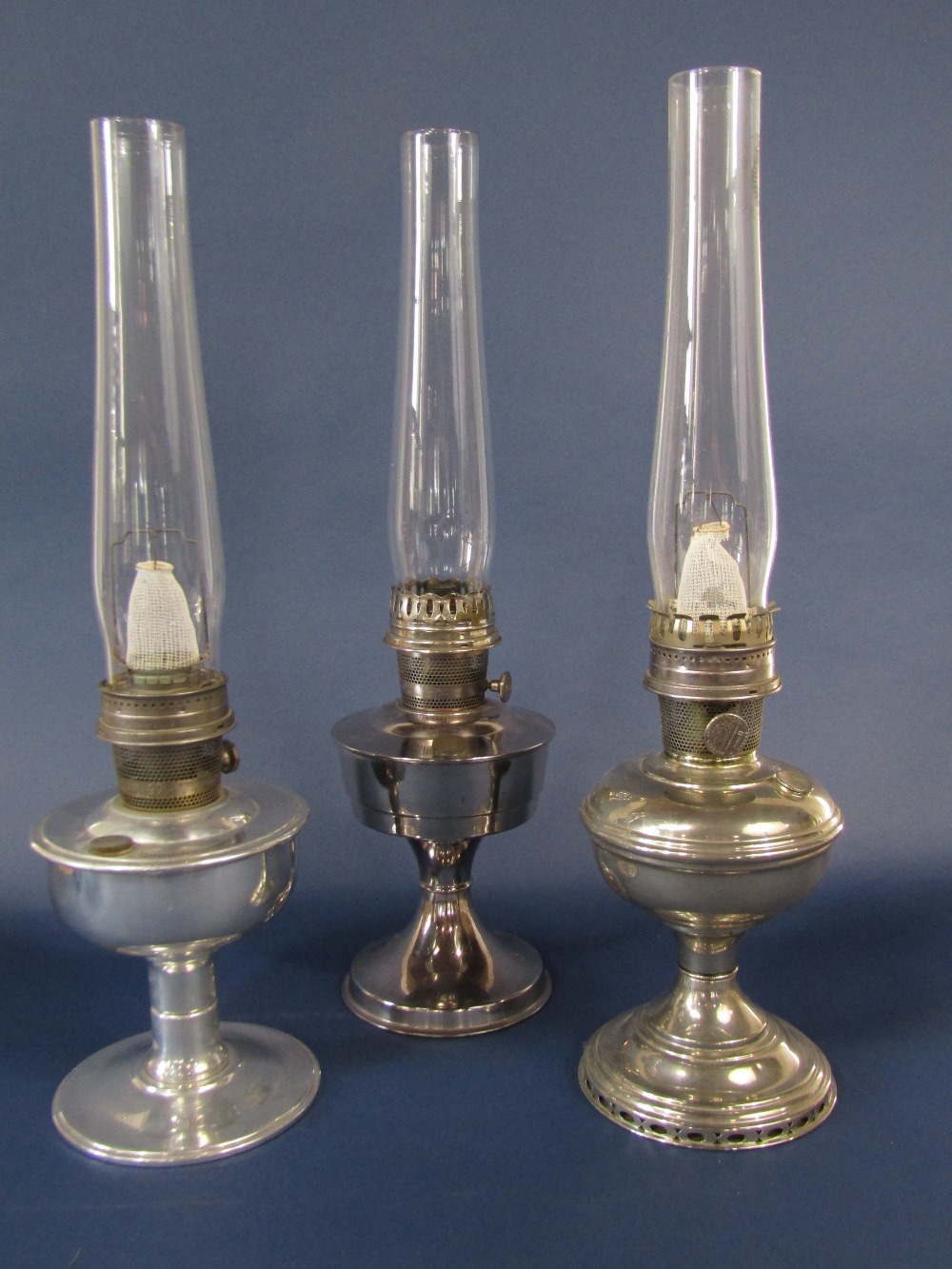 Three similar Aladdin chrome oil lamps, each 28 cm high approx with chimneys (3)