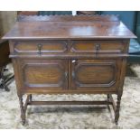 A 1920s Jacobean revival oak side cupboard with geometric mouldings, fitted with two frieze