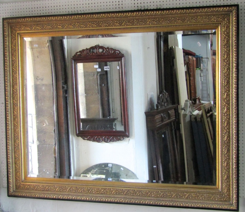 A large contemporary reproduction wall mirror of rectangular form with bevelled edge plate within