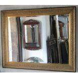 A large contemporary reproduction wall mirror of rectangular form with bevelled edge plate within