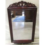 A Georgian style wall mirror of rectangular form, the stepped and moulded mahogany frame with carved